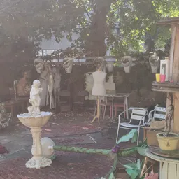 Winkelinterieur met mannequins, kleding aan rekken, bankje en decoratieve objecten zoals een vogelbadje en planten