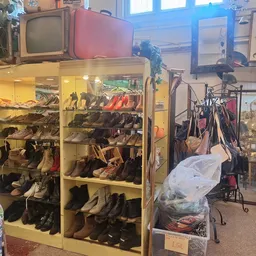 Overzicht van kringloopwinkel met schoenenkast, fietsen, vintage televisie en diverse tweedehands spullen