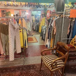 Interieur van kringloopwinkel met kledingrekken, vintage meubels en diverse tweedehands artikelen