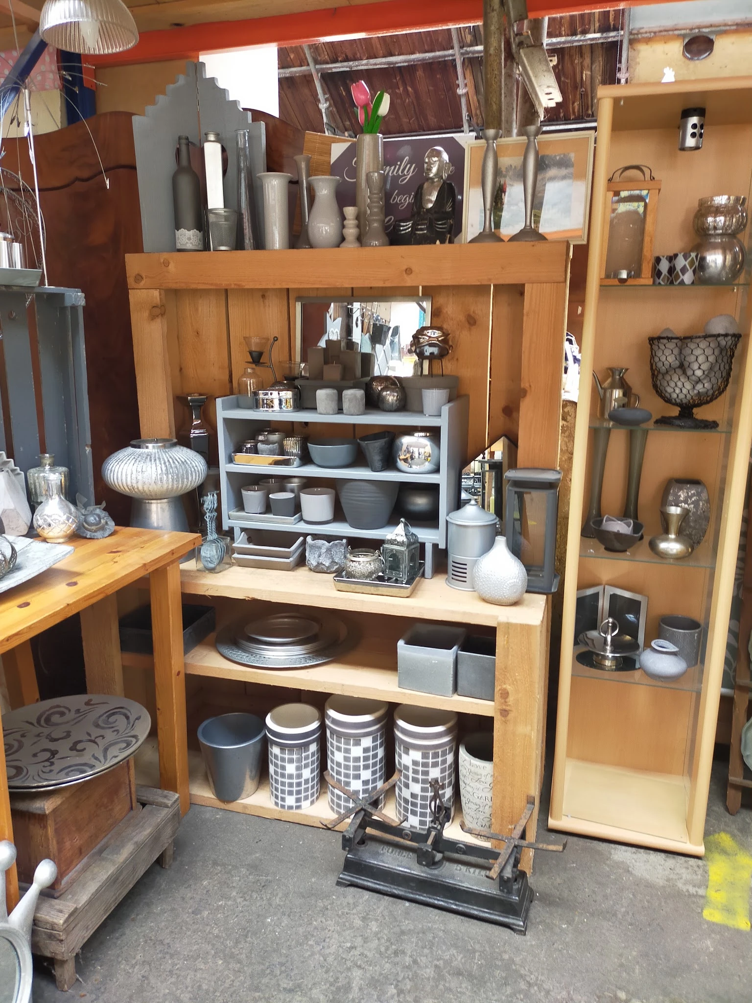 Houten kastjes en stellingen vol met huishoudelijke artikelen, servies, kaarsen en decoratieve items