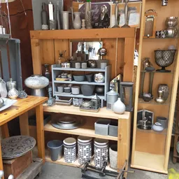 Houten kastjes en stellingen vol met huishoudelijke artikelen, servies, kaarsen en decoratieve items
