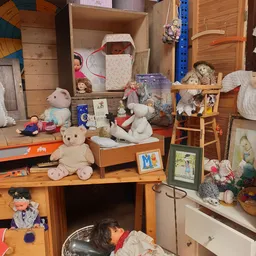 Uitgestalde speelgoed en knuffels op houten meubels en tafels in de winkel