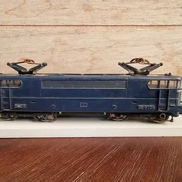 Blauwe elektrische modeltrein SNCF op witte plank tegen houten achtergrond