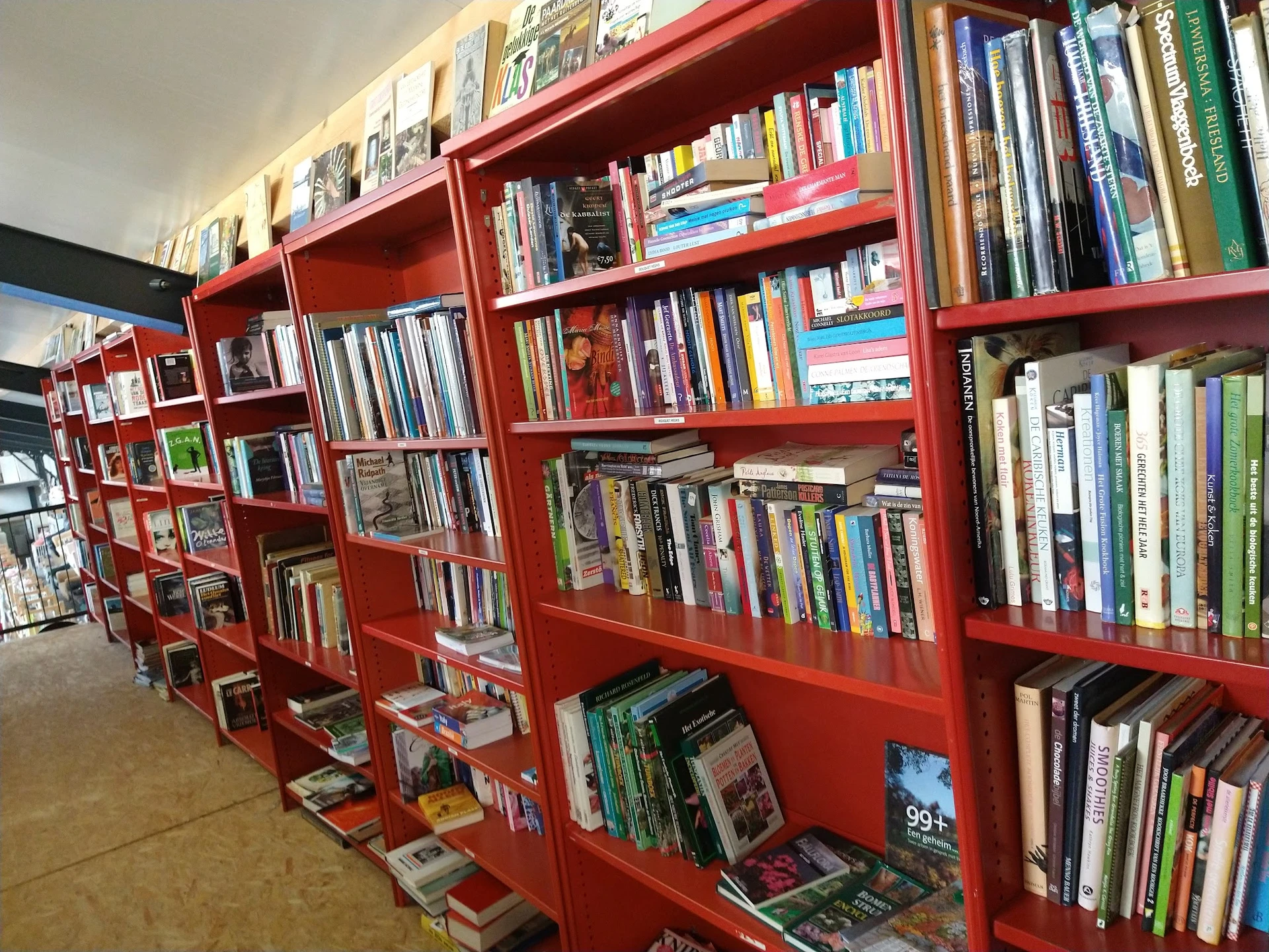 Rode boekenkasten met dvd's, blu-rays en boeken in verschillende vakken