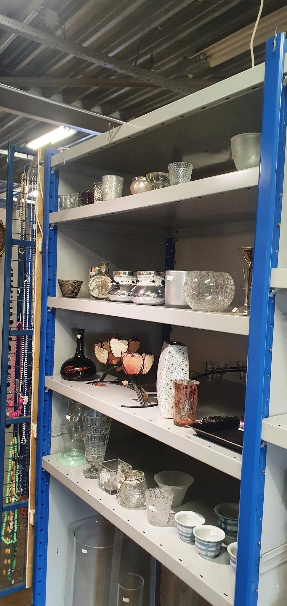 Blauwe stellingkast met decoratieve huishoudartikelen en woonaccessoires in verschillende maten