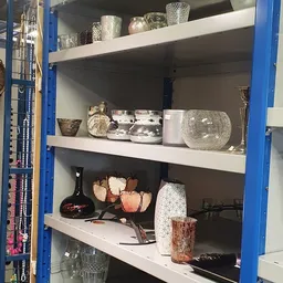 Blauwe stellingkast met decoratieve huishoudartikelen en woonaccessoires in verschillende maten