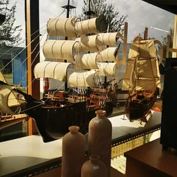 Uitgestalde miniatuurnavels en zeilschepen met egyptische kruiken op display