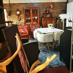 Winkelvloer met zithoeken, vintage meubels, houten kasten en decoratieve objecten