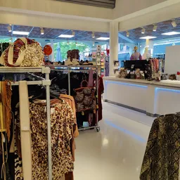 Winkelvloer met kledingrekken, toonbanken en diverse textielwaar in een kringloopwinkel