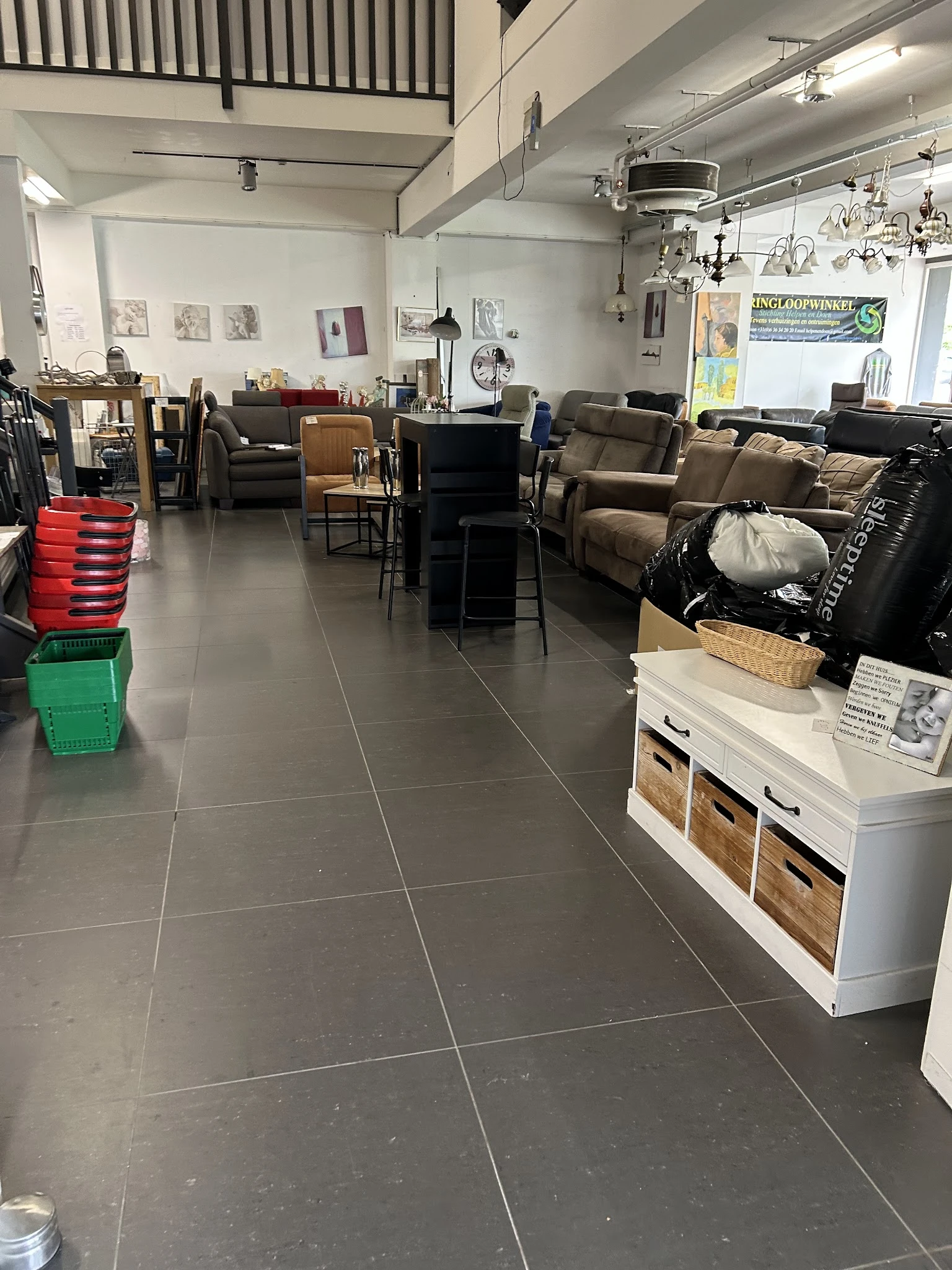 Winkelvloer van kringloopwinkel met meubels, fauteuils, stoelen en kasten uitgestald