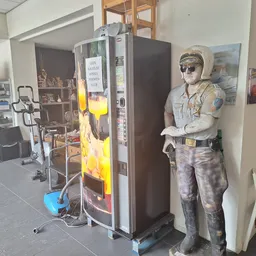 Winkelbinnenruimte met snackautomaatje, kartonnen figuur en diverse items op stellingen