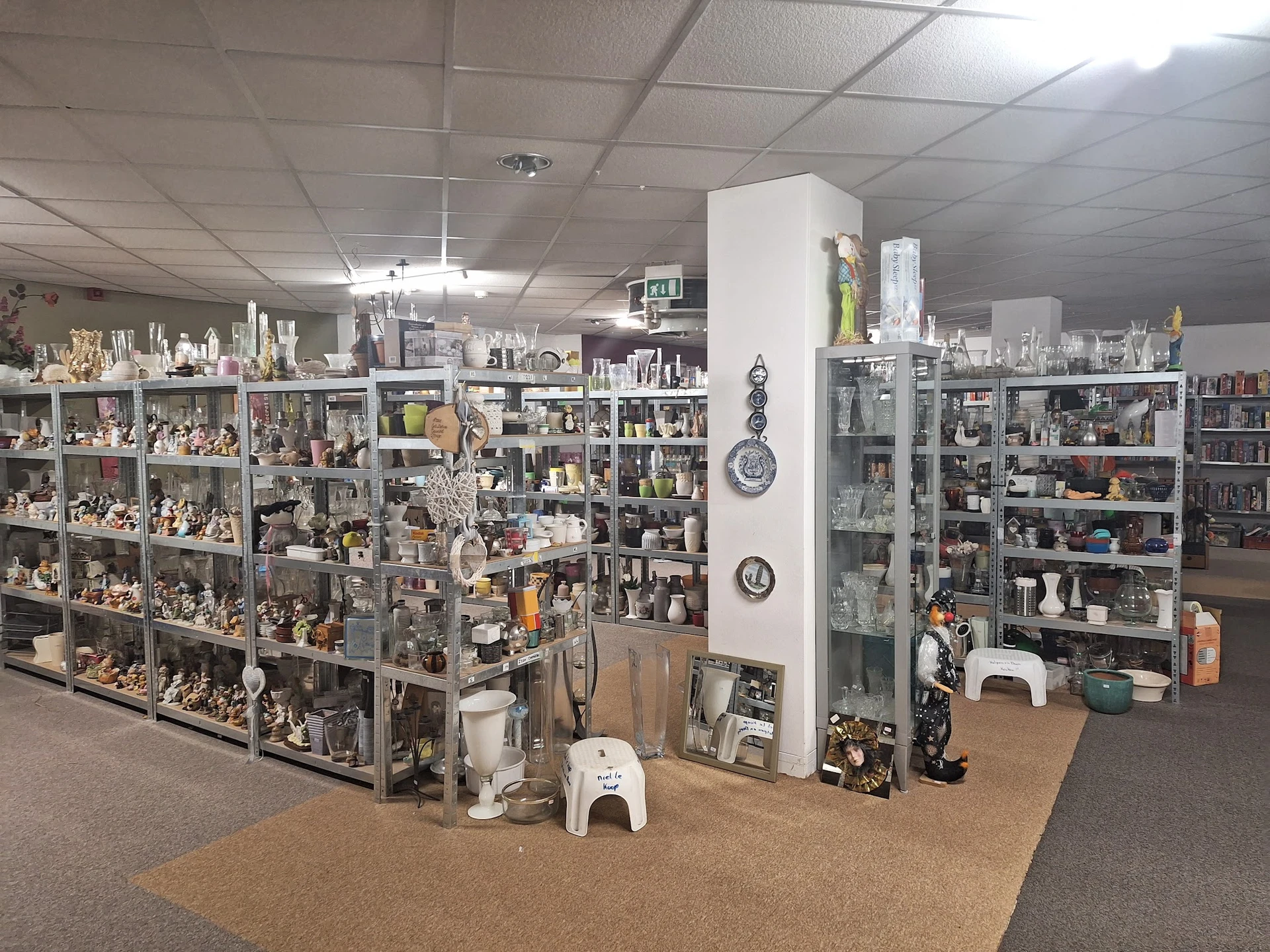 Uitgebreide verzameling decoratieve items, beeldjes en huishoudwaren op stellingen in de winkel