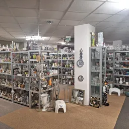 Uitgebreide verzameling decoratieve items, beeldjes en huishoudwaren op stellingen in de winkel