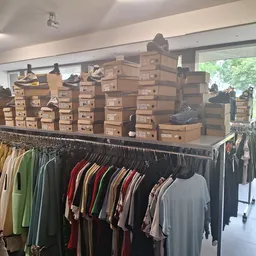 Winkelvloer met rekken tweedehands kleding en grote stapel dozen op displays