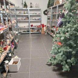 Winkelvloer met stellingen vol decoraties, kunstkerstbomen en kerstversiering aan beide zijden