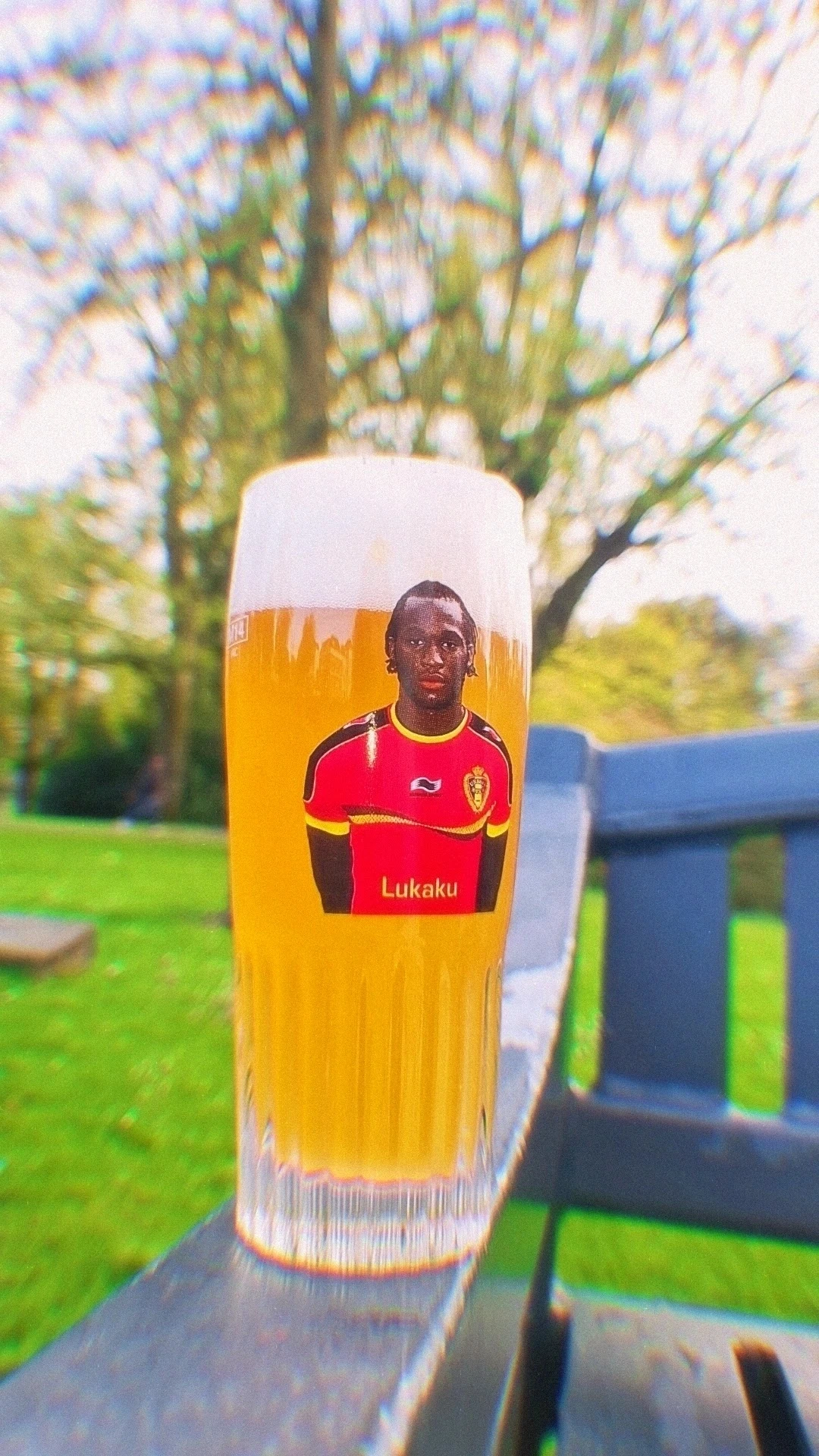 Bierglas met portretetiket van een voetballer, buiten in een tuin