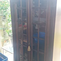 Donkerbruine houten kast met glazen deuren en glas-in-lood ramen