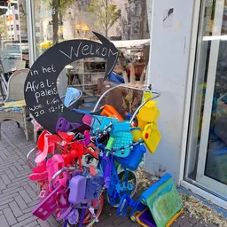 Kleurrijke plastic speelgoed en voorwerpen in verschillende kleuren uitgestald buiten de winkel