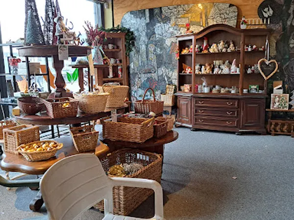 Winkelinterieur met houten meubels, wicker manden, decoratie en verschillende afdelingen vol spullen
