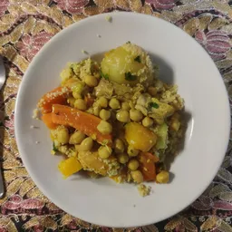 Bord met curryrijst, groenten en erwten op een witte bordrand