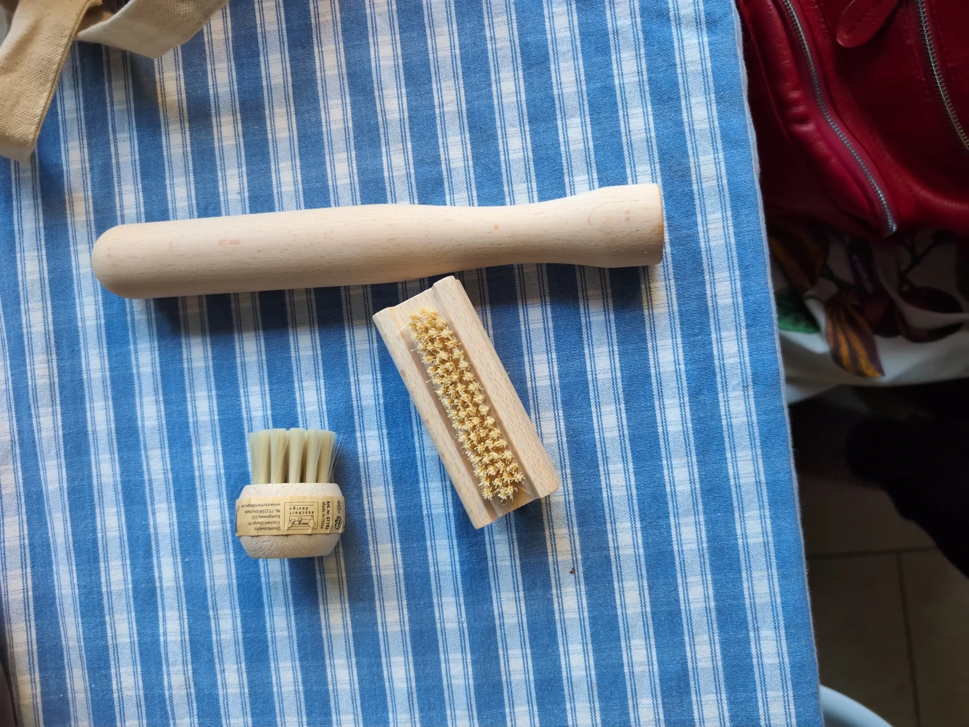 Drie houten schoonmaakborstels op een blauw-wit gestreepte doek