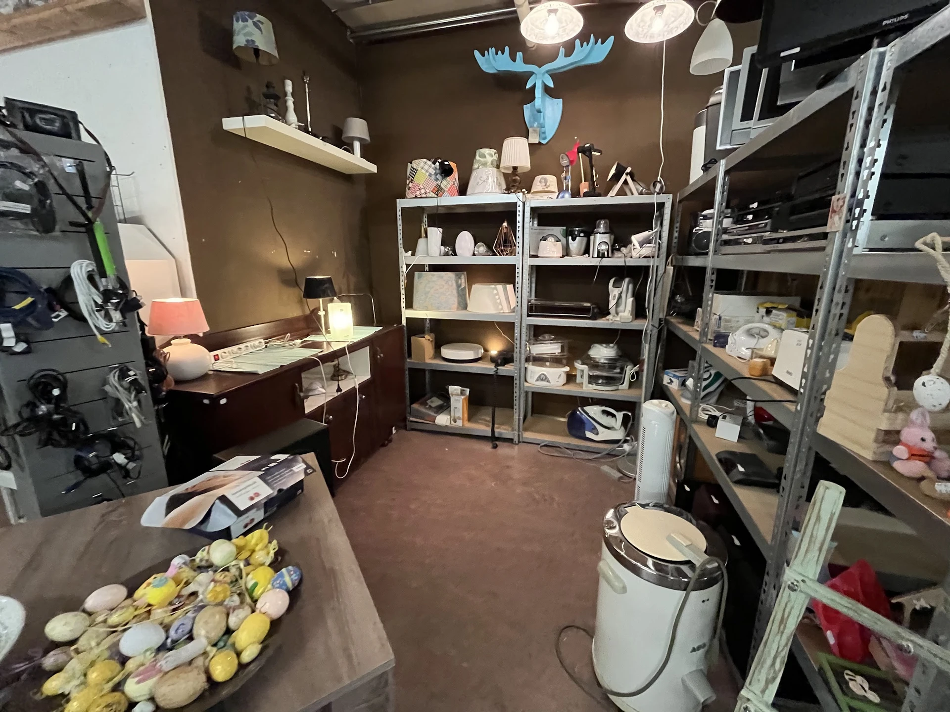 Winkelinterieur met stellingen, toonbank met gele items, decoratie aan plafond en werkruimte
