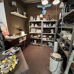 Winkelinterieur met stellingen, toonbank met gele items, decoratie aan plafond en werkruimte