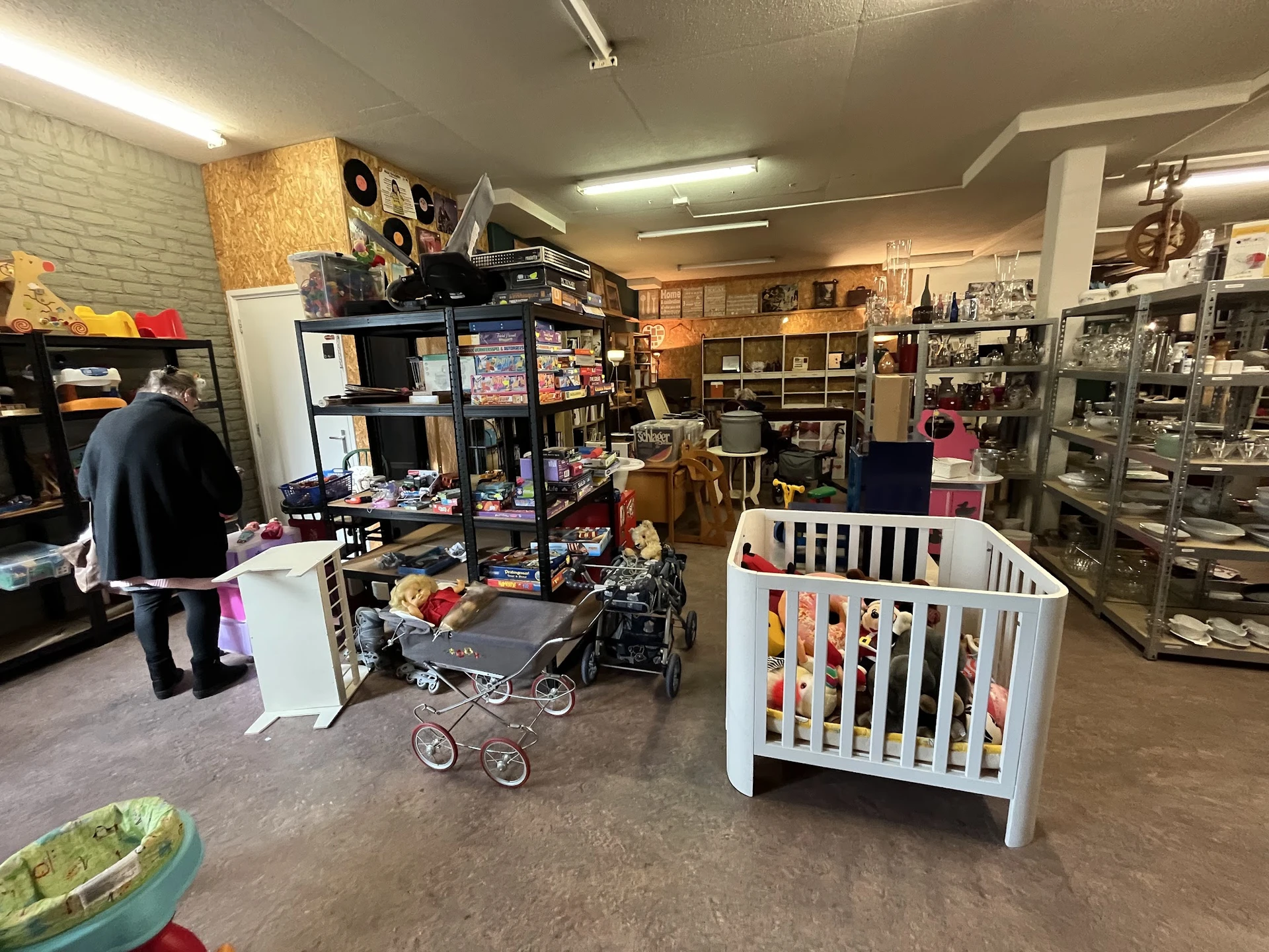 Winkelvloer met stellingen, babywiegjes, speelgoed en diverse tweedehandsartikelen