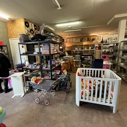 Winkelvloer met stellingen, babywiegjes, speelgoed en diverse tweedehandsartikelen