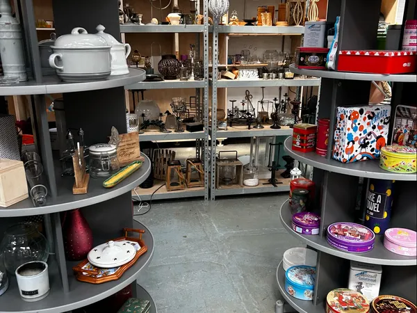 Winkelinterieur met zwarte stellingen vol huishoudspullen, servies, decoraties en gebruiksartikelen