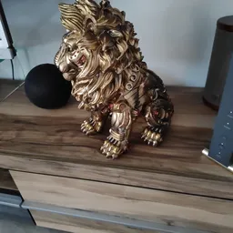 Gouden decoratief leeuwenbeeldje op een houten tafel