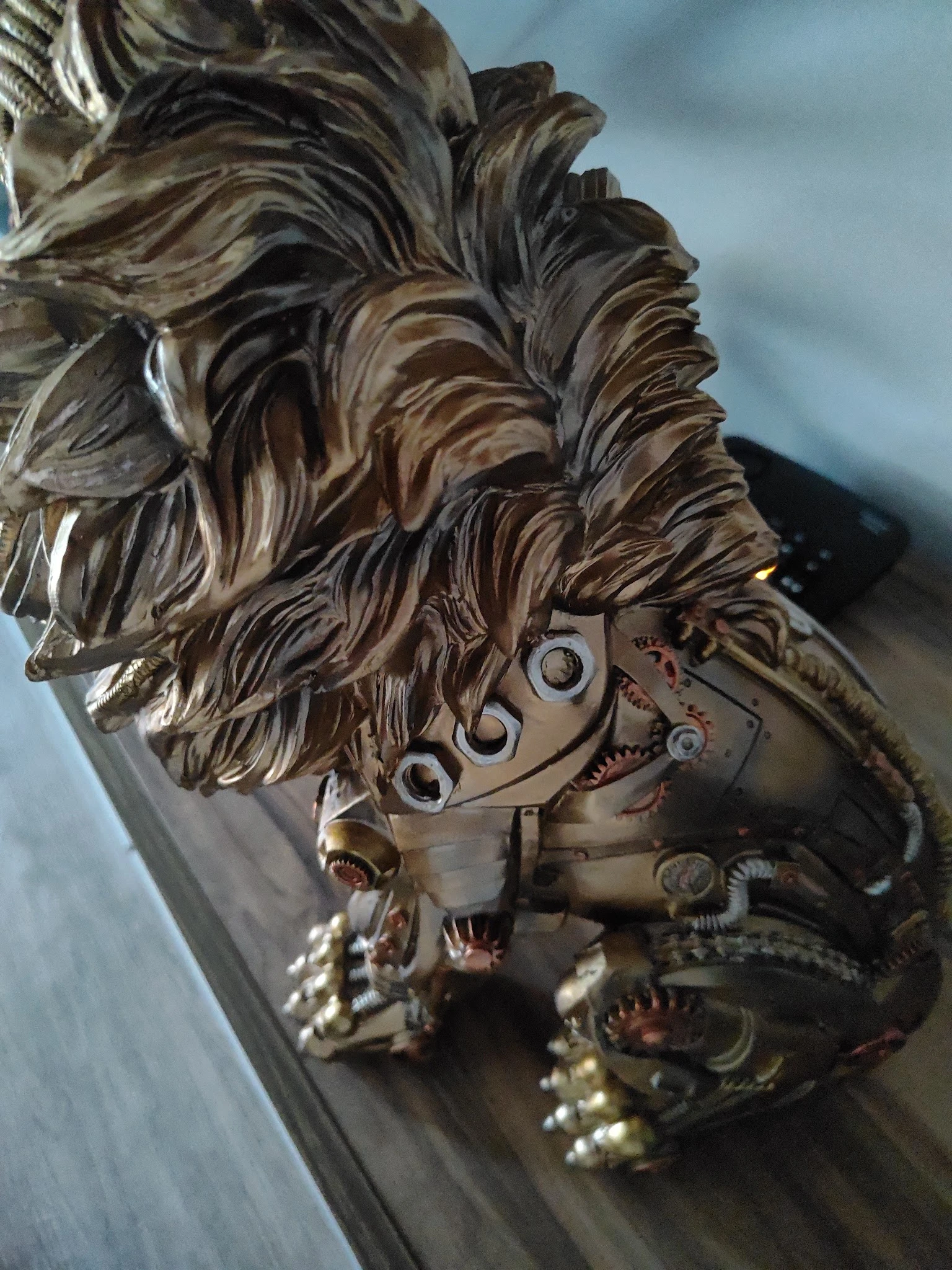 Close-up van een decoratief bronzen beeldhouwwerk met golvend haar en mechanische elementen