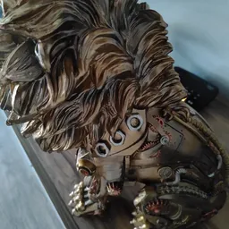 Close-up van een decoratief bronzen beeldhouwwerk met golvend haar en mechanische elementen