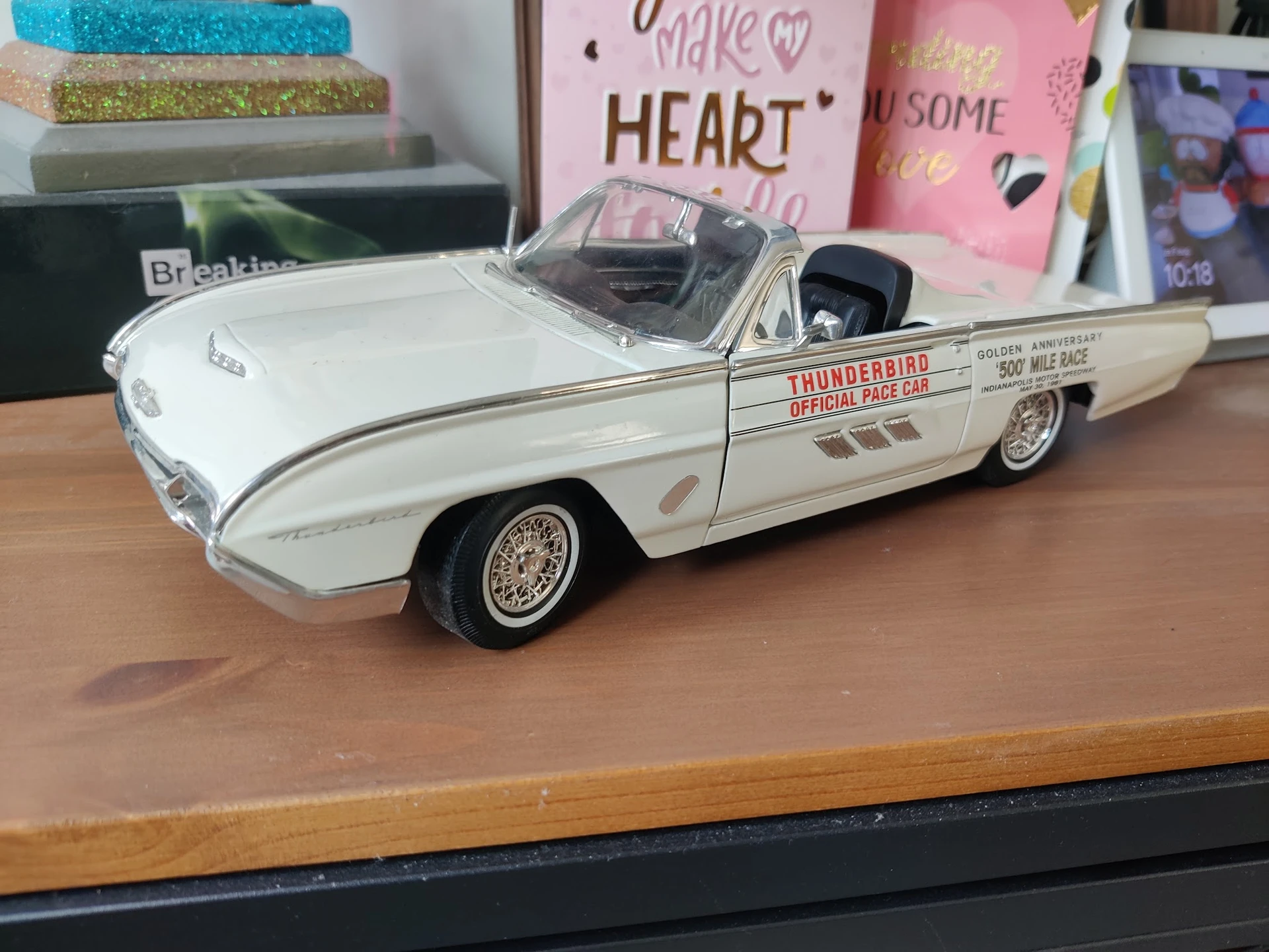 Wit modelauto'tje van een vintage Thunderbird cabriolet op een houten tafel