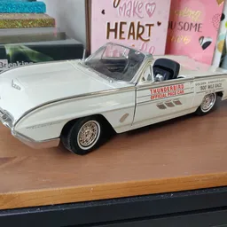 Wit modelauto'tje van een vintage Thunderbird cabriolet op een houten tafel
