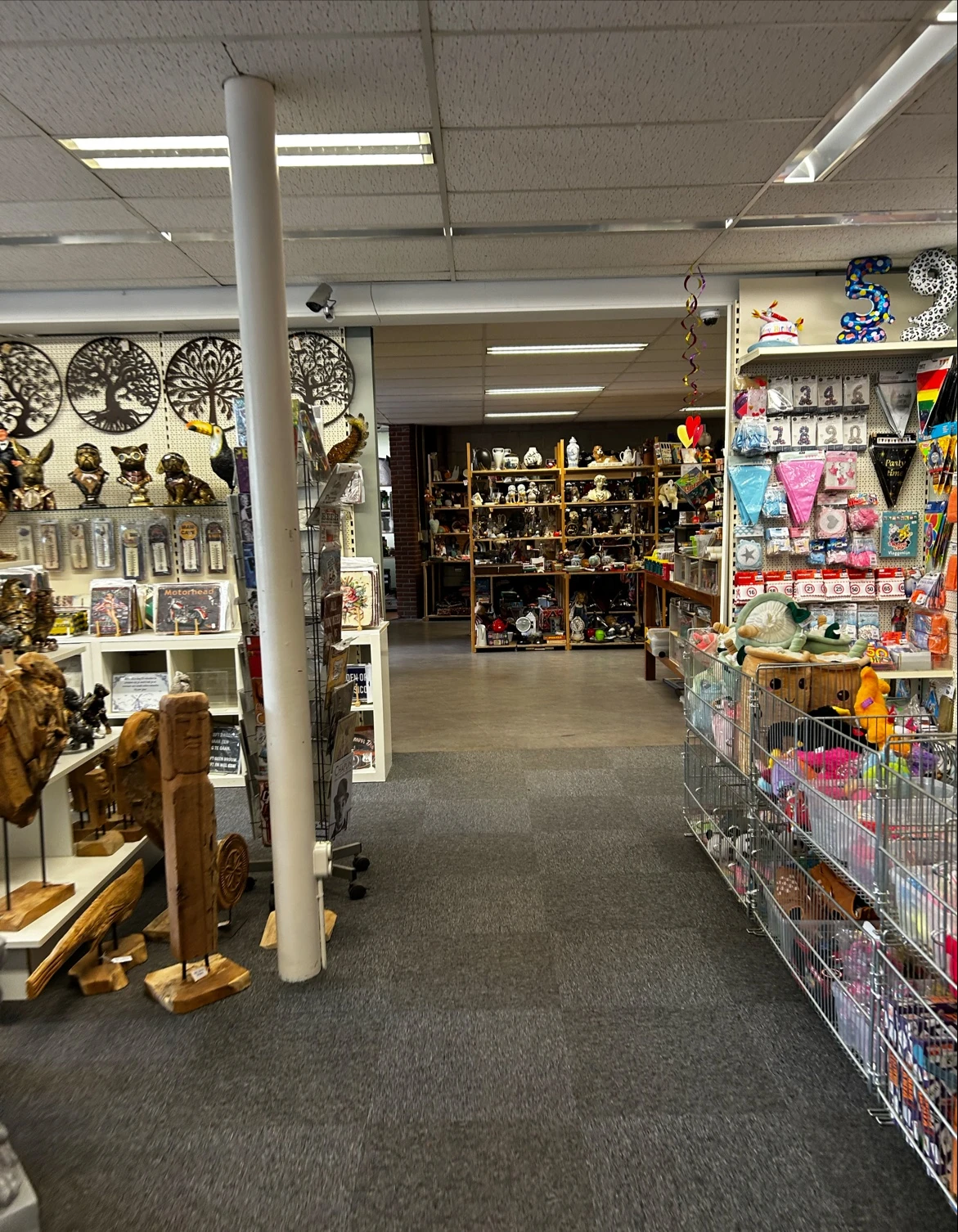 Winkelvloer van kringloopwinkel met stellingen vol beeldjes, decoratie en huishoudartikelen