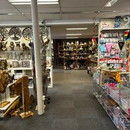 Winkelvloer van kringloopwinkel met stellingen vol beeldjes, decoratie en huishoudartikelen