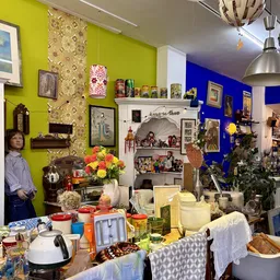 Kleurrijke winkelinterieur met geel en blauw geverfd en diverse gebruiksartikelen, decoratie en meubels uitgestald