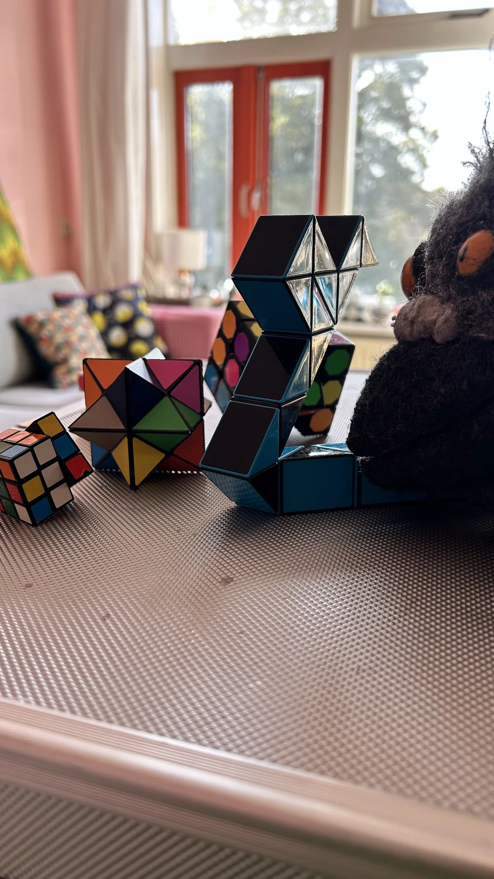 Verschillende puzzels en kubus-spellen uitgestald op een tafel, waaronder Rubik's cubes en andere logicaspellen