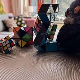 Verschillende puzzels en kubus-spellen uitgestald op een tafel, waaronder Rubik's cubes en andere logicaspellen