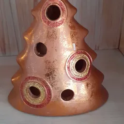 Close-up van een decoratieve keramische vogelverschrikker in roze en goud met glitterafwerking