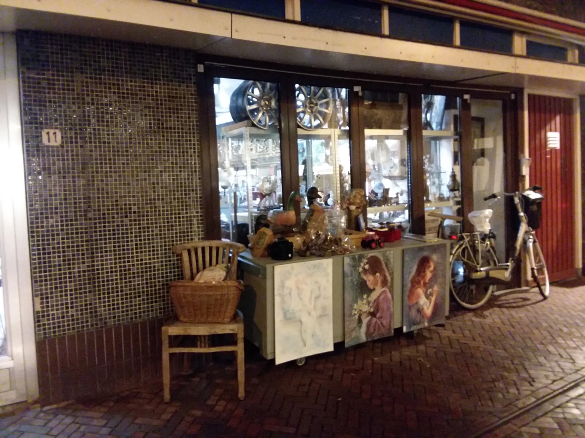 Winkelinterieur met uitgestalde meubels, decoraties en een fiets bij de etalage