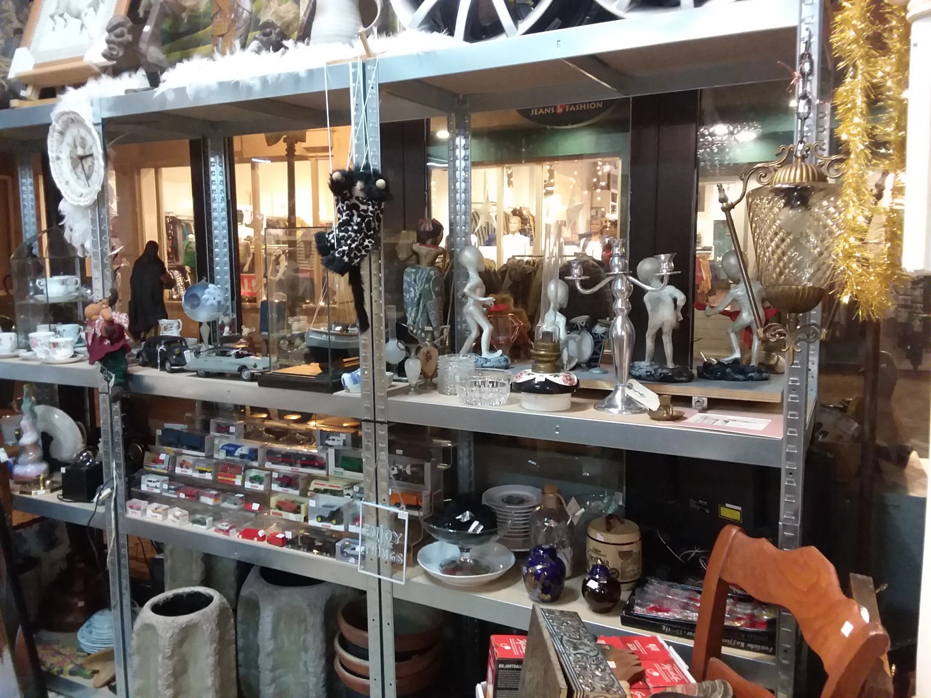 Vitrinekast met uitgestalde mode-artikelen, mannequins, accessoires en diverse spullen