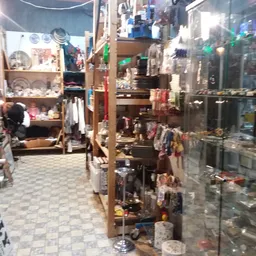 Binnenaanzicht van kringloopwinkel met display-kasten, stellingen en diverse uitgestalde spullen