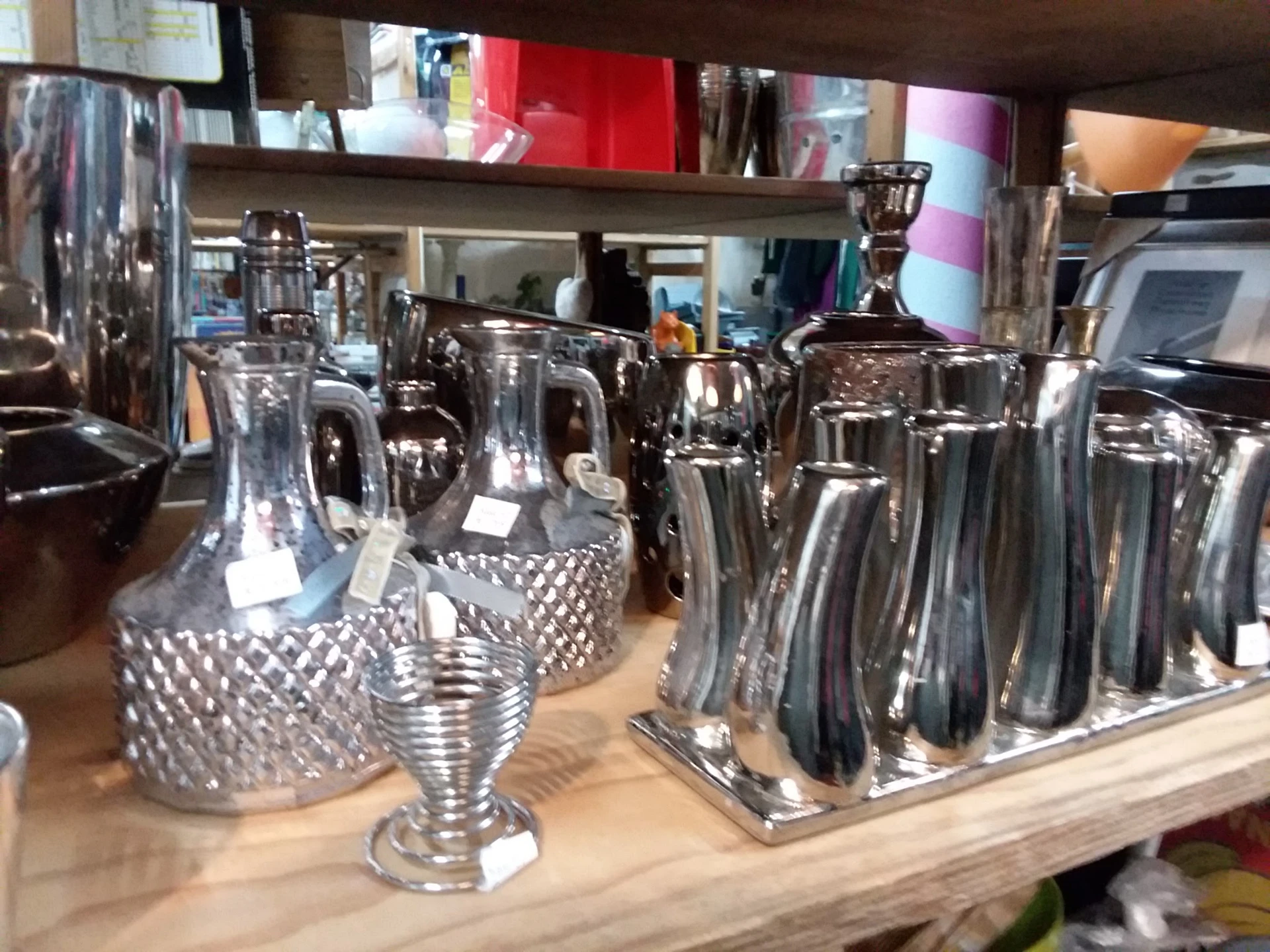 Zilverkleurige serviezen, kannen en tafeldecoraties op een houten display