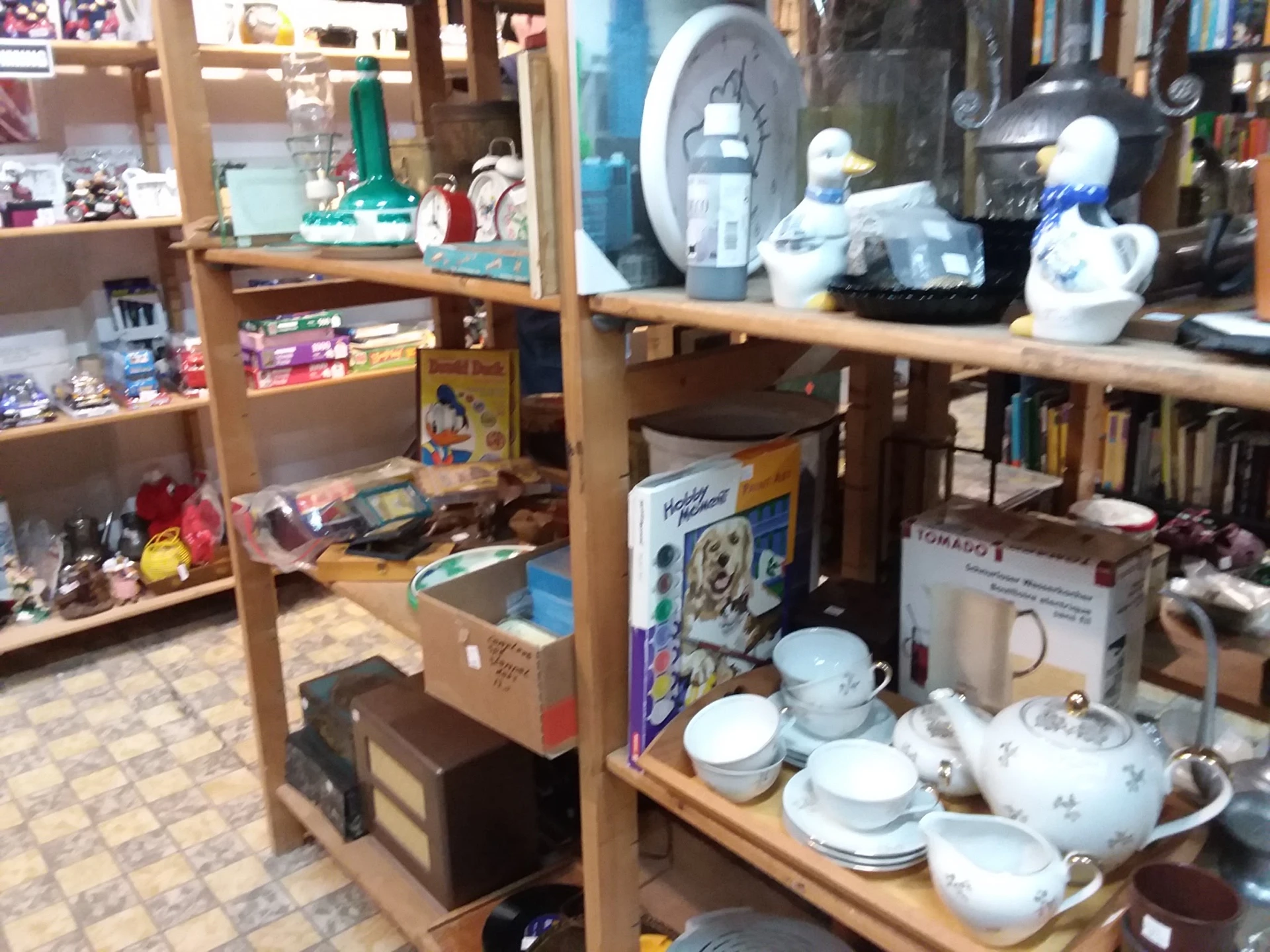 Houten stellingen met uitgestalde serviesgoed, vazen en huishoudelijke artikelen in de winkel