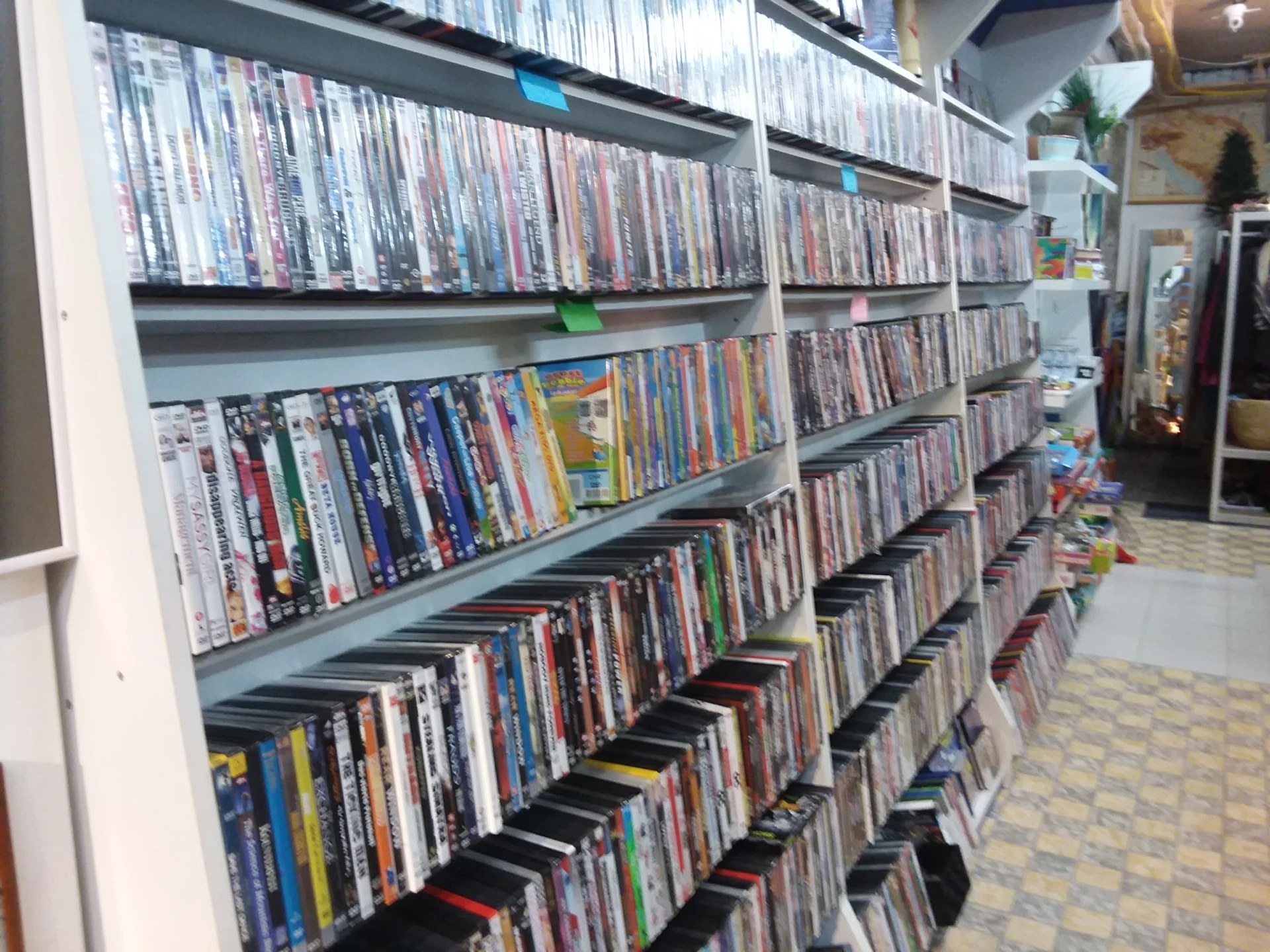 Uitgebreide collectie dvd's en blu-rays op meerdere schappen en in dozen op de grond