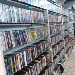 Uitgebreide collectie dvd's en blu-rays op meerdere schappen en in dozen op de grond