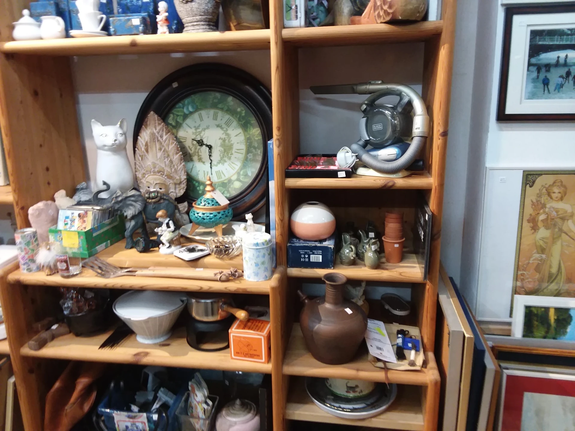 Houten stellingkast met diverse gebruiksartikelen: servies, beeldjes, camera's, huishoudelijke spullen