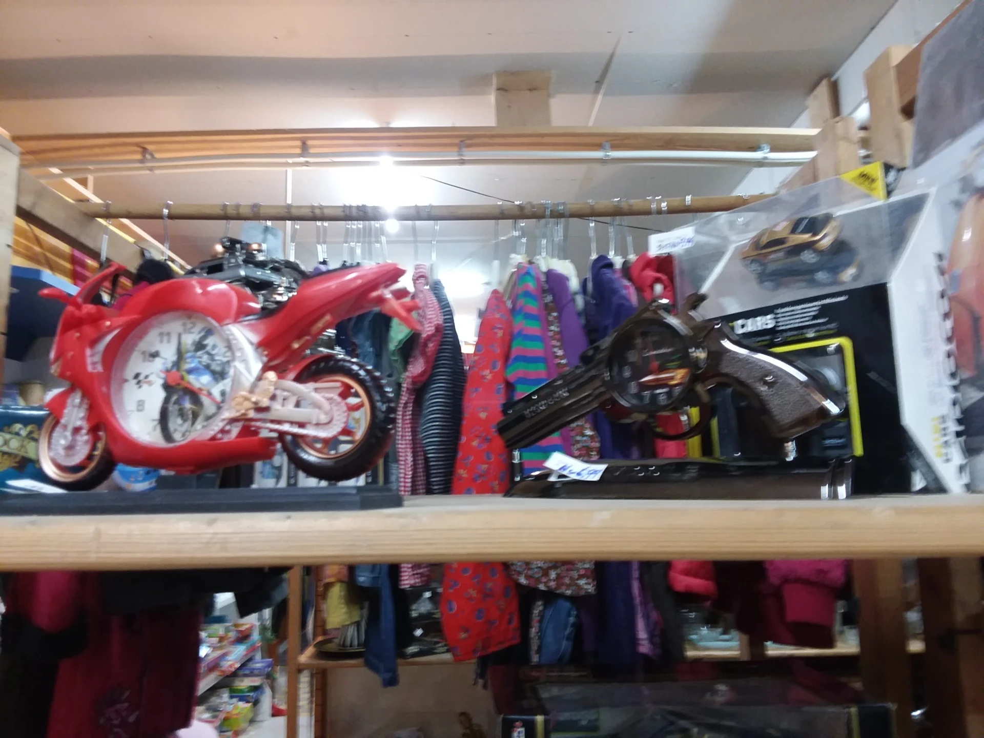 Stellingkast met speelgoed waaronder rode motorfiets, zwarte auto en diverse kleurrijke items